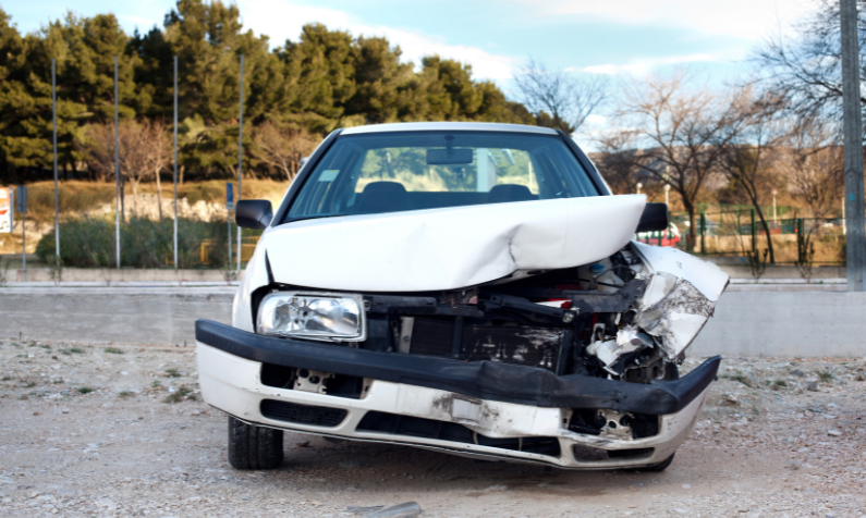 Valkoinen auto on kolaroitu ja odottaa korjausta