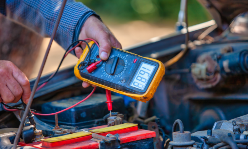 Mekaanikko mittaa yleismittarilla akun kuntoa